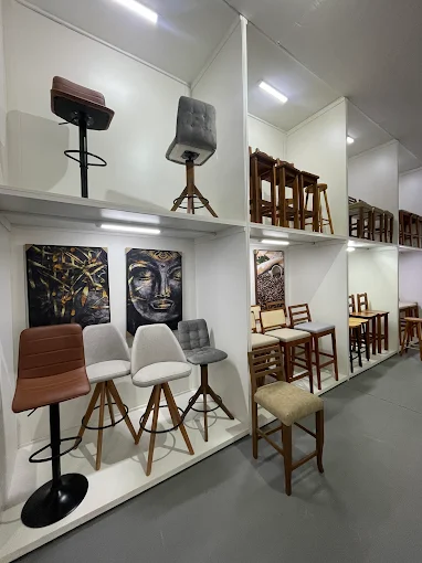 Banquetas e cadeiras estofadas expostas em prateleiras na loja Doce Lar
