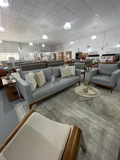 Sofá cinza com almofadas e mesa de centro no showroom da Doce Lar