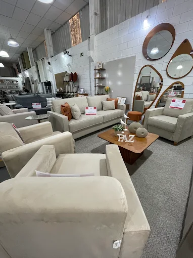 Ambiente com sofá claro, poltrona, mesa de centro e espelhos orgânicos
